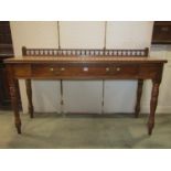 An Edwardian oak hall/serving table with raised turned baluster rail over a frieze drawer raised