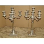 Pair of silver plated five branch candelabra on turned columns and square cut bases