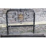 A Victorian cast iron bedstead with arched tubular outer rail and supports and decorative pierced