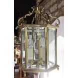 A brass hall lantern, hexagonal with three branches with faceted glass panels