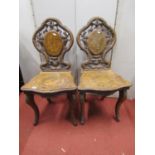 A pair of 19th century Tyrolean side or hall chairs, principally in walnut, the shaped and moulded