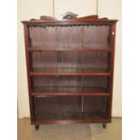 An Edwardian stained open bookcase with three adjustable shelves, moulded detail and shaped pediment