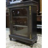 A Victorian ebonised pier cabinet with cast ormolu mounts and inlay detail, enclosed by an arched