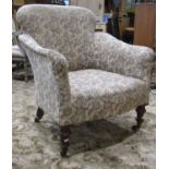 A Victorian tub chair with shaped outline, floral cream ground patterned upholstered finish and