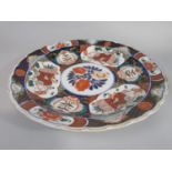 A 19th century imari type charger with male character and floral decoration, with shaped rim and