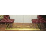 A traditional club fender, the corner seats upholstered in buttoned maroon leather, set within a