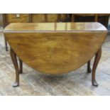 A Georgian mahogany dropleaf dining table of oval form, raised on four pad feet and scrolled