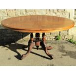 A Victorian walnut loo table, the oval top raised on a platform base with turned column supports and
