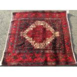 Unusual square Senneah rug with intricate decoration and red highlights upon a navy blue ground, 115