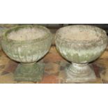 A pair of reclaimed garden urns of circular tapered and fluted form raised on square cut bases, 35