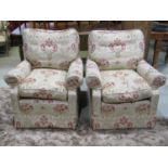 A pair of good quality traditional easy chairs with rolled arms, repeating floral patterned