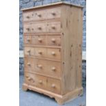 A stripped pine chest of six long drawers disguised as eighteen small drawers, with turned bun