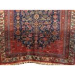 Antique Persian rug with geometric medallion and still life decoration upon a blue ground with
