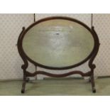 An Edwardian mahogany toilet mirror of oval form with inlaid chequered stringing and skeleton