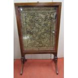 A 19th century firescreen with slide glazed wings, set on swept supports, 58cm wide when closed,