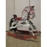 A vintage child's rocking horse with simulated dapple grey painted finish and fixed rockers