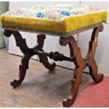 A late Regency mahogany centre stool, raised on a pair of X shaped supports, united by a turned