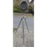 A large vintage style electric floorstanding drum shaped theatre light raised on a folding and