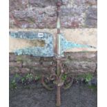 An antique reclaimed wrought iron weather vane with weathered verdigris copper pointer and scroll