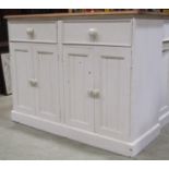 A partially painted freestanding pine kitchen side cupboard enclosed by two pairs of rectangular