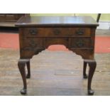 A Georgian walnut lowboy, the top with cross banded borders, the front elevation enclosed by four