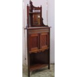 A late Victorian mahogany freestanding corner cupboard with raised rectangular bevelled edge