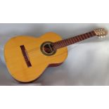 A six stringed Spanish acoustic guitar labelled BM made Espana along with a carrying case