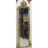 A full length antique style dressing/pier mirror, the moulded arched gilt frame with scrolling