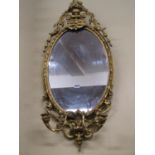 A 19th century gilded wall mirror of oval form, the frame with repeating detail, set beneath a