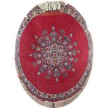 Persian circular rug with eccentric central floral medallion upon a red ground, 100cm diameter