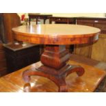 An early 19th century American tea table, the circular top raised on a substantial square cut column