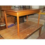 A 1960s/70s teak pull-out extending dining table of rectangular form with moulded outline and single