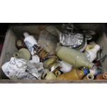 A distressed canvas covered wooden trunk containing an assorted collection of earthenware bottles