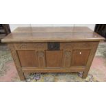An 18th century oak coffer with plank top, the front elevation enclosing three panels and