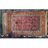 An Afghan wool carpet bag with geometric detail upon a red field with shell, bead and tassel borders