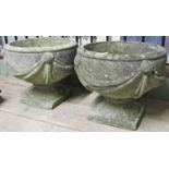 A pair of reclaimed garden urns of circular form with classical trailing swag detail and raised on