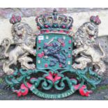 A heavy cast iron armorial wall plaque with rampant lion, crown, scrolling acanthus detail,