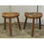 A pair of country made milking stools with through jointed stick supports and demi-lune seats, 28 cm