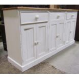 A partially painted pine floorstanding kitchen dresser base enclosed by three pairs of rectangular