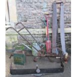 A vintage single wheeled push hoe, galvanised watering can, two two-man cross cut saws, four long
