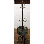 A decorative ironwork lamp standard, raised on a tripod base, with central tray and stylised leaf