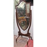 An Edwardian mahogany cheval glass, the shield shaped frame enclosing a bevelled edge mirror