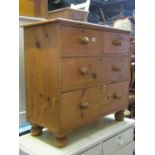 A small Victorian stripped pine bedroom chest of two long and two short drawers raised on turned bun