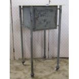 A painted and distressed metal cabinet with square marble top raised on tubular supports with