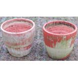 A pair of weathered terracotta garden planters of circular tapered form, with repeating incised