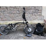 A Brompton folding electric bike and accessories (lacks seat, framed clip)