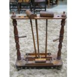 A Victorian croquet stand in pine with ring turned and tapered columns, pierced circular mallet