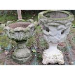A weathered cast composition stone garden urn with circular acanthus leaf bowl raised on a socle