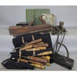 A collection of wood working tools including chisels, mallet, plane and four books relating to