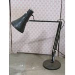 A vintage anglepoise table lamp with disc shaped platform base and racing green colourway